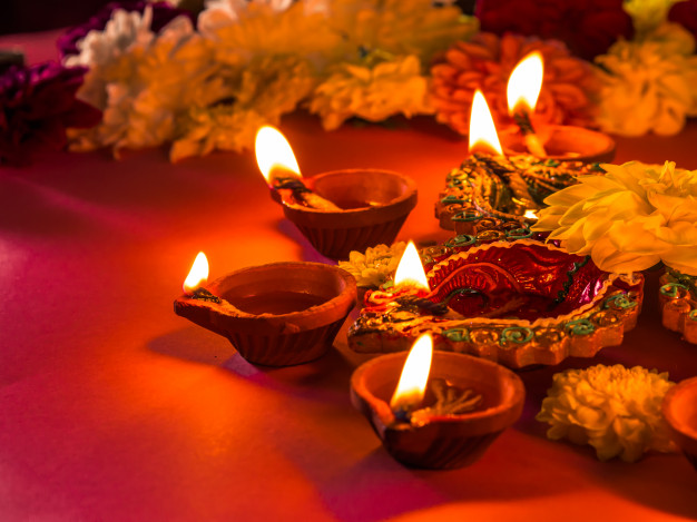 colorful-traditional-clay-diya-lamps-flowers_53476-2419
